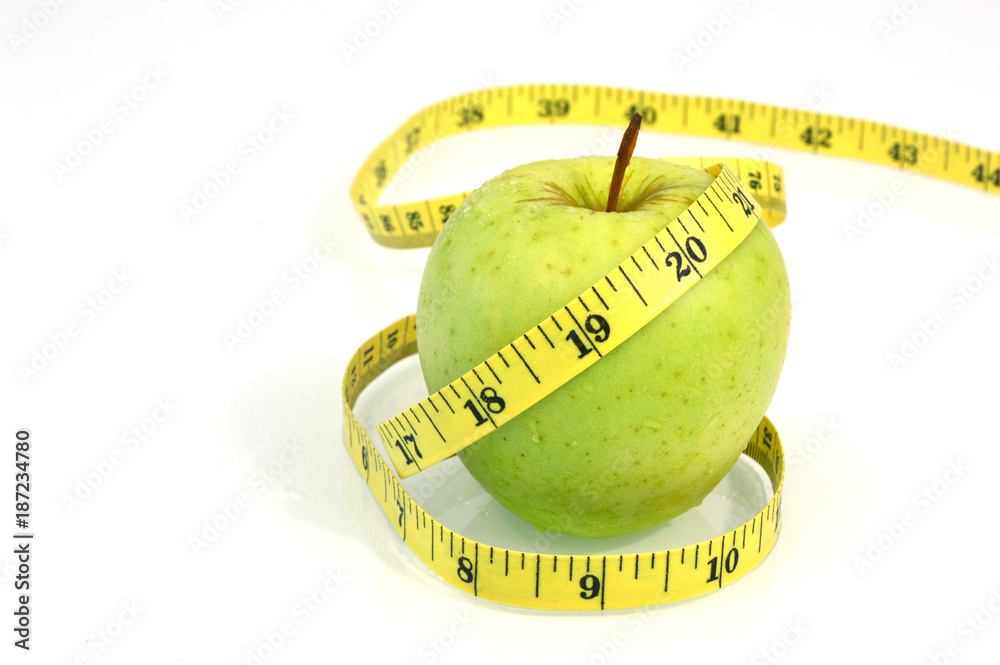 Wall mural green apple with measuring tape on white background