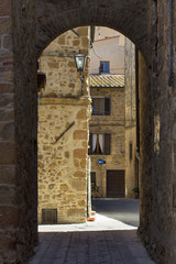 Obraz premium view through arch in old city in Italy