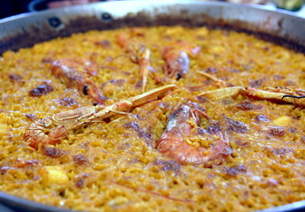 Runde, gusseiserne Pfanne mit safrangelber Paella und Meeresfrüchten