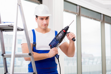 Repairman working with power drill in workshop