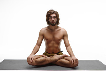 Isolated studio portrait of peaceful flexible strong young unshaven Caucasian male with flat...