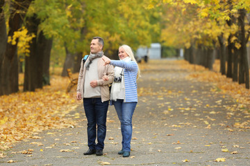 Happy mature couple taking walk in park