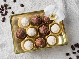 Candy with Coconut in a Gold Box of the Cell on the Table of the Coffee beans