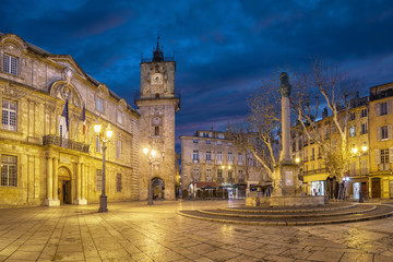 Fototapeta na wymiar Town Hall square at dusk with City Hall (Hotel de Ville) building, clock tower and fountain in Aix-en-Provence, France