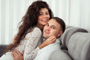 Front view of a loving young couple kissing in the living room at home