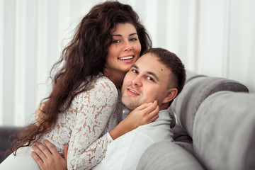 Fototapeta premium Front view of a loving young couple kissing in the living room at home