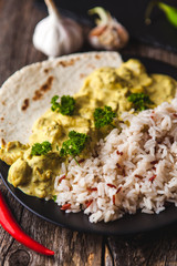 Handmade chicken curry tikka masala with basmati rice on wooden table