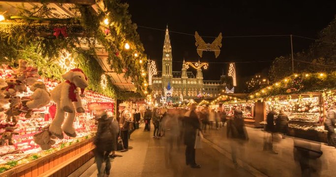 VIENNA, AUSTRIA – DECEMBER 2015 : Moving timelapse of christmas market on slider at night with Rathaus / City Hall and christmas lights in view