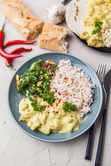 Handmade chicken curry tikka masala with basmati rice and broccoli on grey table