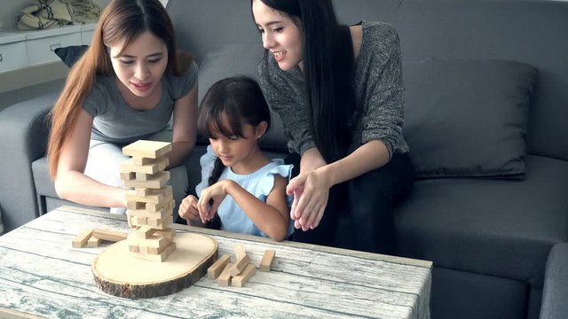 Young girl playing block games at home with nanny. Young attractive teenage girl having fun playing game with her nanny in living room..