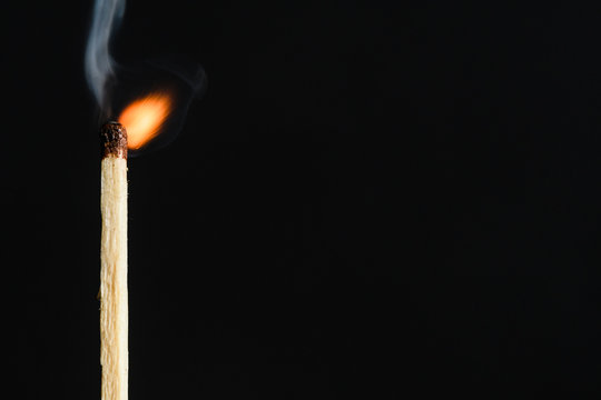 The time of the decay of the dying match flames on a black background closeup