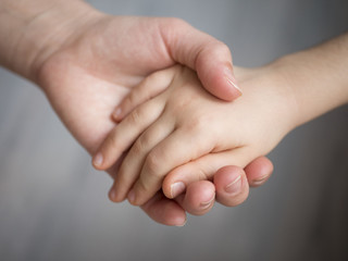 mother holding baby hand