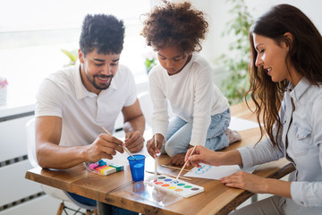 Mother and father drawing together with their child