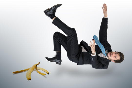 Businessman slipping on a banana peel.