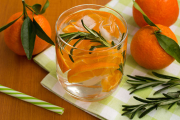 Detox water with mandarins and rosemary on the green napkin