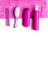 Basic hair care in bathroom. Comb, shampoo, spray, towel on white background top view copyspace