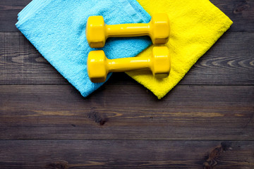 Fitness equipment. Dumbbells on dark wooden background top view copyspace