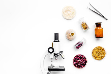 Fototapeta na wymiar Food safety. Wheat, rice and red beans near microscope on white background top view copyspace