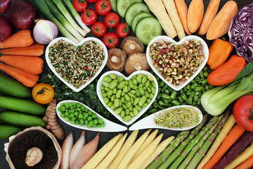 Healthy diet superfood concept with fresh vegetables loose and in heart shaped and curved bowls with food high in antioxidants, anthocyanins, vitamins, minerals and dietary fibre.