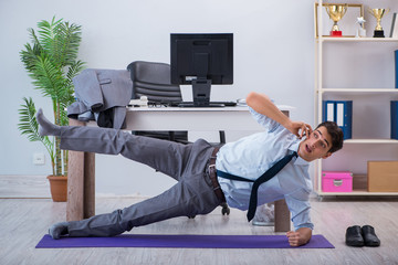 Businessman doing sports in office during break