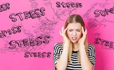 Young woman feeling stressed on a pink background
