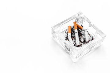 Smoking. Half-smoked cigarettes in ashtray on white background copyspace
