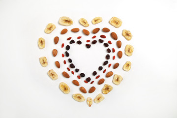 heart shaped mandala of dried fruits and nuts - symbols of jewish holiday Tu Bishvat