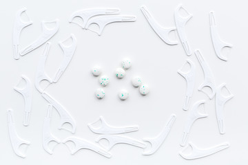 Teeth care. Floss and toothpaste on white background top view