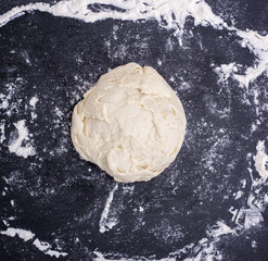 ball of wheat yeast dough on a black surface