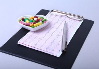 Stethoscope, RX prescription and colorful assortment pills and capsules on plate.