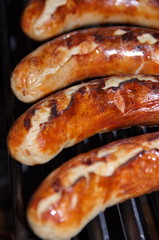 Vier Bratwürste auf dem Grill