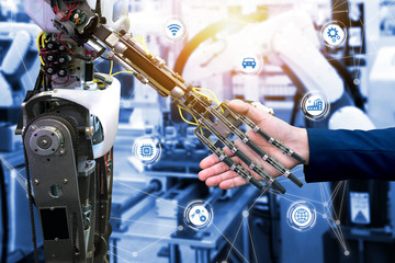 Cyber communication and robotic trend and artificial intelligence concepts. Industrial 4.0 Cyber Physical Systems concept. Robot and Engineerer human holding hand with handshake and graphic.