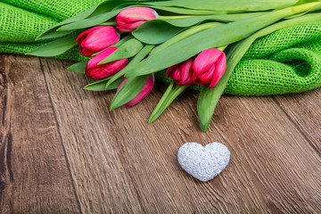 Tulips and heart on a wooden table