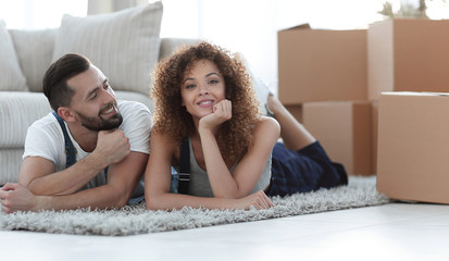 concept of moving to a new home. Happy couple lying on the floor