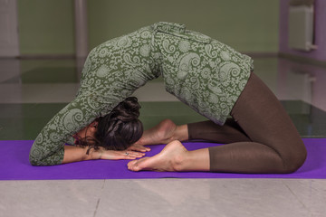 Lady shows yoga positions in fitness class