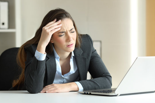 Businesswoman suffering migraine at office