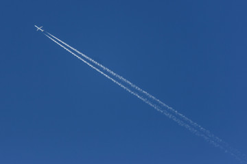 Plane leaving a white contrail, crossing the picture