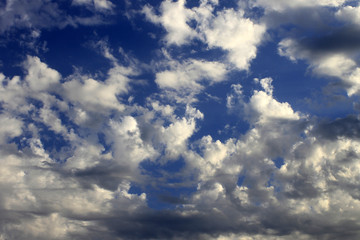 Cielo dramático, nubes densas blancas hacen formas en el cielo azul..