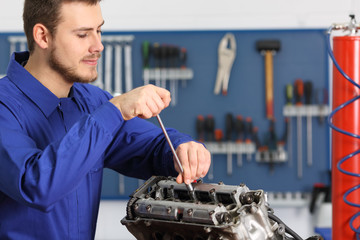 Mechanic repairing a motorbike engine in a workshop