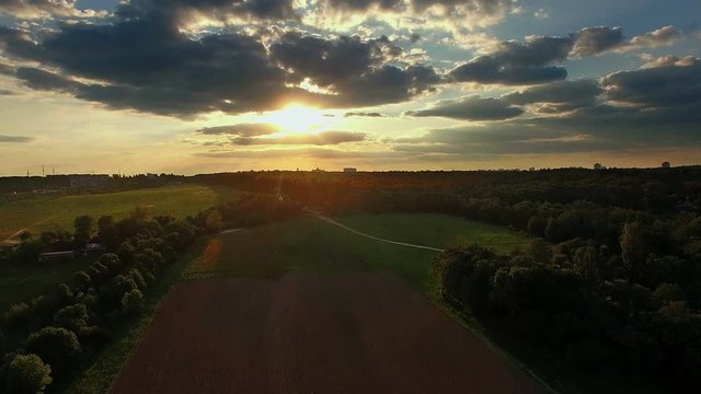 Flying over the plowed field at sunset, Flying backwards over farm fields at sunset 4K, lit by the setting soltse field 4k aerial view