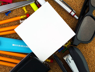 Empty white square sheet of paper for your text. There are pencils, pen, scissor, yellow...
