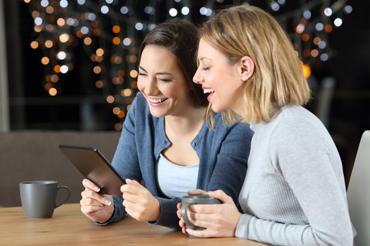 Two Friends Watching Media Content In A Tablet In The Night