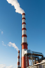 combined heat and power plant, from the pipe goes white smoke against a background of pure blue sky