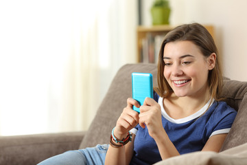 Fototapeta na wymiar Teen using a blue smartphone at home