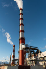 combined heat and power plant, from the pipe goes white smoke against a background of pure blue sky