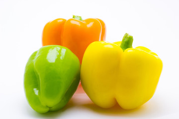 Green, yellow and orange pepper are isolated on a white background