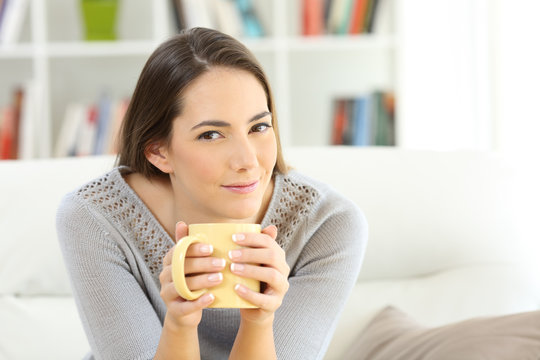 Housewife looking at camera holding a coffee cup