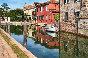 Naklejka premium Torcello, Venice. Colorful houses on Torcello island, canal and boats. Summer, Italy