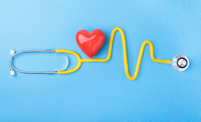 Red heart and a stethoscope on blue background
