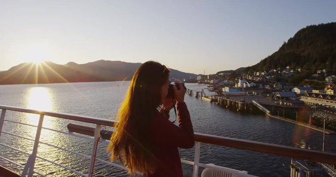 Alaska Cruise ship passenger photographing city of Ketchikan from cruise ship deck while sailing Inside Passage. Ketchikan is a famous Alaska cruise ship destination for tourist sightseeing.